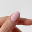 Close-up of a hand with a pink nail on a plain background