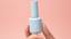 Close-up of Gel Break™ nail strengthener bottle held against pink background