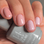 Hand with pink nail polish holding a bottle of 14 Day Mani gel polish.